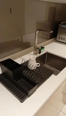 a kitchen counter with a sink with a laptop keyboard at Quill Residence - Blissful Urban Condo by Azmila in Kuala Lumpur
