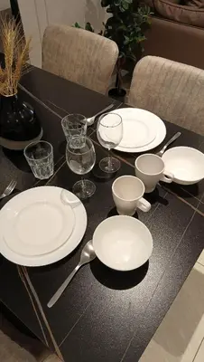 a black table with white plates and bowls and spoons at Quill Residence - Blissful Urban Condo by Azmila in Kuala Lumpur