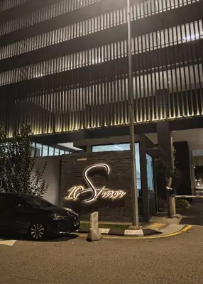 a car parked in front of a building with a sign at Bedin Hotels in Kuala Lumpur