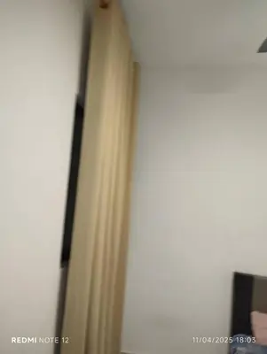 a room with a curtain and a white wall at Flora Residency Setapak in Kuala Lumpur