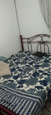 a bed with a blue and white blanket on it at Flora Residency Setapak in Kuala Lumpur