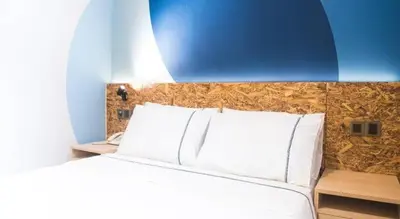 a bedroom with a large white bed with a blue wall at I LUX I-Hotel Kuala Lumpur in Kuala Lumpur