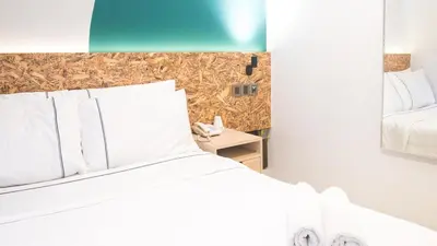 a bedroom with a white bed and a mirror at I LUX I-Hotel Kuala Lumpur in Kuala Lumpur