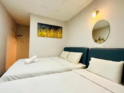 two beds in a small room with a mirror at Triple B Hotel in Kuala Lumpur