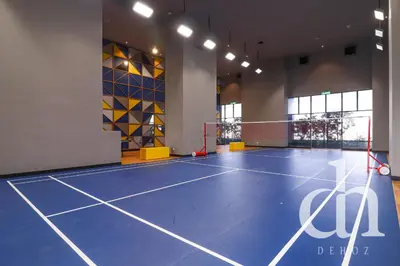 a gym with a blue tennis court with a net at Trion KL Residence by Dehoz Suites in Kuala Lumpur