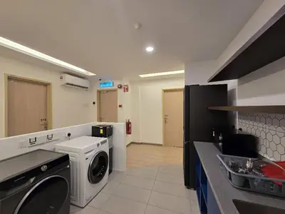a kitchen with a washer and dryer in a room at The Backpackers Hut Chow Kit in Kuala Lumpur