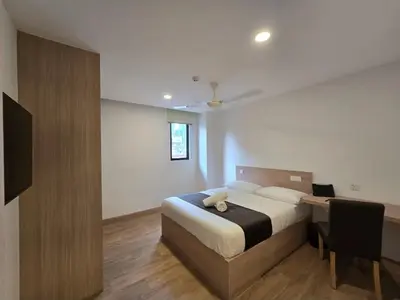 a bedroom with a bed and a desk with a stuffed animal on it at The Backpackers Hut Chow Kit in Kuala Lumpur