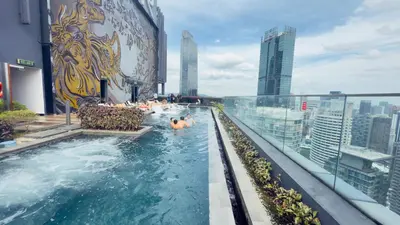 a pool on the roof of a building with people in it at Star Residence Suites KLCC Sky pools in Kuala Lumpur