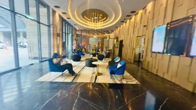 a lobby with people sitting in chairs in a building at Star Residence Suites KLCC Sky pools in Kuala Lumpur