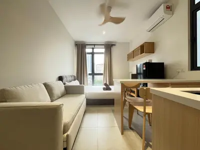 a living room with a couch and a kitchen at Arte Mont Kiara By Comfortcorner in Kuala Lumpur