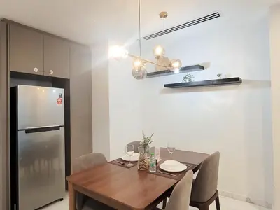 a dining room with a table and a refrigerator at Eaton Residence KLCC Kuala Lumpur in Kuala Lumpur