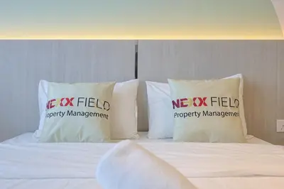 a bed with pillows with me x field on it at Riveria City Home Plus in Kuala Lumpur
