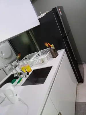 a kitchen with a white sink and a black refrigerator at Vortex Suites KLCC by Comfy Stay in Kuala Lumpur
