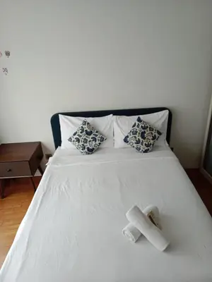 a white bed with a cross laying on top of it at Vortex Suites KLCC by Comfy Stay in Kuala Lumpur