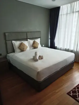 a bedroom with a large bed with two candles on it at Vortex Suites KLCC by Comfy Stay in Kuala Lumpur