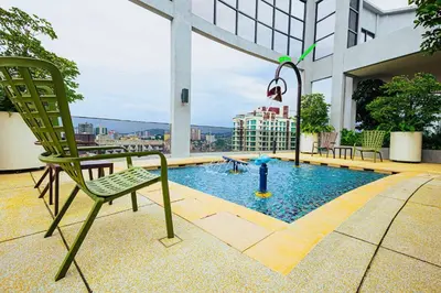 a chair sitting on top of a building with a pool at The Atrium at Jalan Ampang by OKBnB- Modern Cozy 3 Bedroom Apartment 4 Mins to KLCC in Kuala Lumpur