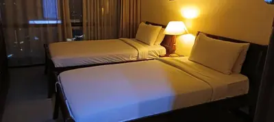 two beds in a hotel room with a lamp at Times Square apartment klcc in Kuala Lumpur