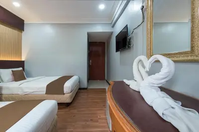 a hotel room with two beds with swan towels at Hotel Grand Orchard in Kuala Lumpur