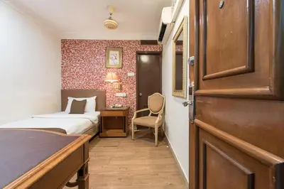a bedroom with a bed and a desk and a door at Hotel Grand Orchard in Kuala Lumpur
