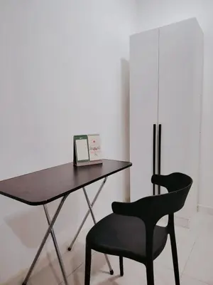 a desk with a laptop and a black chair at Netflix - City View Pano Studio with Skypool, Free parking and 5 mins to MRT in Kuala Lumpur