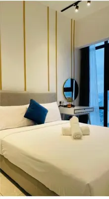 a bedroom with a large white bed and a chair at Bukit Bintang in Kuala Lumpur