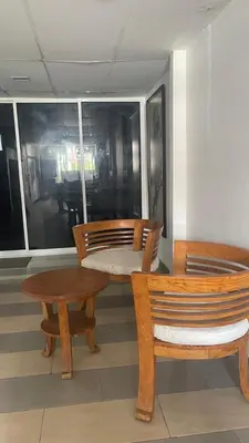 two wooden chairs and a table and a bench at J Hotel Masjid India KL in Kuala Lumpur