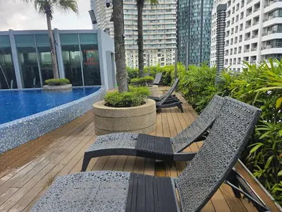 a balcony with chairs and a pool on a building at Vortex suites klcc by musab in Kuala Lumpur