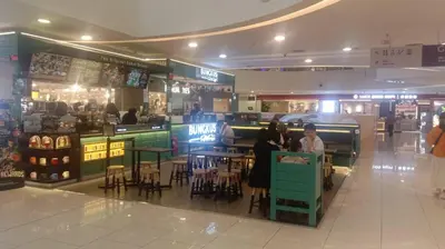 a group of people sitting at a bar in a shopping mall at QUILL RESIDENCE by ASHNAS in Kuala Lumpur