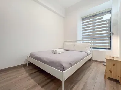 a white bed in a white room with a window at KLCC Agile 雅居乐民宿-吉隆坡 I 双子塔 I Walking distance to MRT & TRX & Bukit Bintang I 中英马客服 Chinese English Malay in Kuala Lumpur