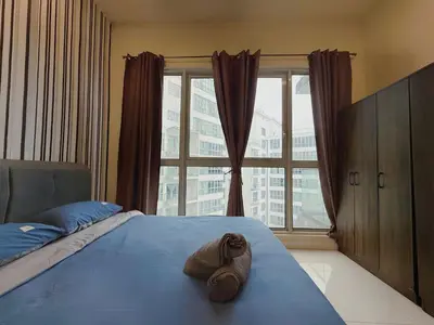 a bedroom with a blue bed with a large window at Spacious Family 2BR Balcony Comfy Regalia Suites in Kuala Lumpur