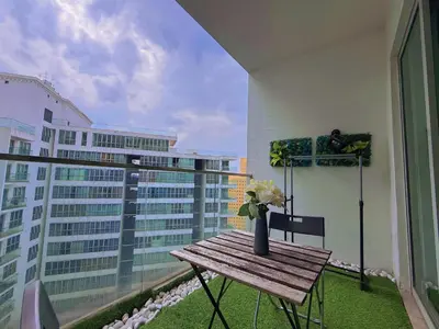 a balcony with a wooden table and a vase of flowers at Spacious Family 2BR Balcony Comfy Regalia Suites in Kuala Lumpur