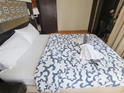 a bed with a blue and white comforter on it at Seri Bukit Ceylon in Kuala Lumpur