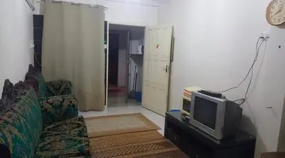 a living room with a couch and a tv at Zam Zam Homestay in Kuala Lumpur