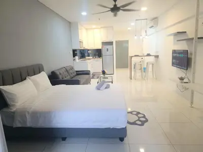 a bedroom with a large bed and a living room at Studio in Kuala Lumpur