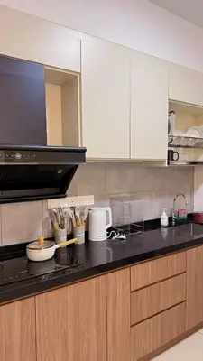 a kitchen with white cabinets and a black counter top at M Vertica KL Cheras Velocity KLCC View in Kuala Lumpur