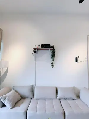 a white couch in a living room with a shelf on the wall at 2BR unit in Razak City Residence by Lisa Homestay in Kuala Lumpur