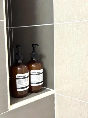 two bottles of soap sitting on a shelf in a wall at 2BR unit in Razak City Residence by Lisa Homestay in Kuala Lumpur