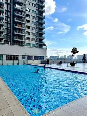 a swimming pool with blue water in front of a building at 2BR unit in Razak City Residence by Lisa Homestay in Kuala Lumpur