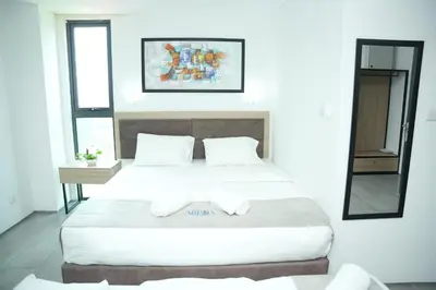 a hotel room with two beds and a mirror at Arena Suites Kuala Lumpur in Kuala Lumpur