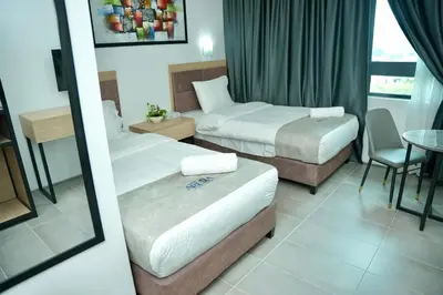 a hotel room with two beds and a table at Arena Suites Kuala Lumpur in Kuala Lumpur