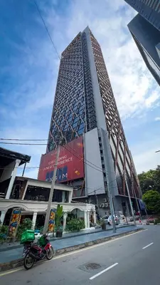 a motorcycle parked in front of a tall building at Scarletz Suite KLCC By Light House 4 in Kuala Lumpur