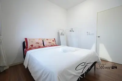 a bedroom with a bed with white sheets and pink pillows at Gt home-Kuala Lumpur View 3Bedroom 2Bathroom in Kuala Lumpur