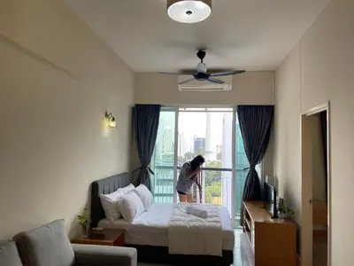 a woman standing next to a bed in a room at Kuala lampur city centre in Kuala Lumpur