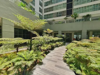 a walkway in a building with trees and plants at Regalia residence suite view in Kuala Lumpur