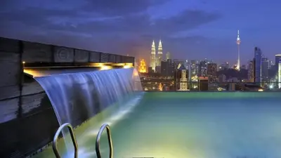 a view of a city skyline at night with a waterfall at Regalia residence suite view in Kuala Lumpur