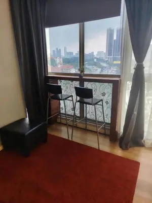 a room with two chairs and a large window at Regalia residence suite view in Kuala Lumpur
