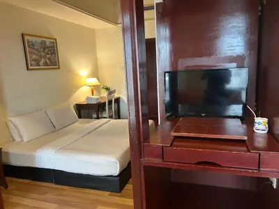 a bedroom with a bed and a dresser with a television at Holiday Residence at times square kL in Kuala Lumpur