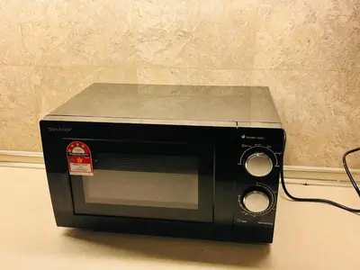 a black microwave sitting on top of a counter at Holiday Residence at times square kL in Kuala Lumpur