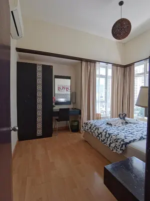 a bedroom with a bed and a desk with a computer at Seri Bukit Ceylon Apartment Bukit Bintang in Kuala Lumpur