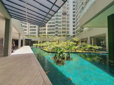 a large swimming pool in a building with buildings at Regalia residence suite view in Kuala Lumpur
